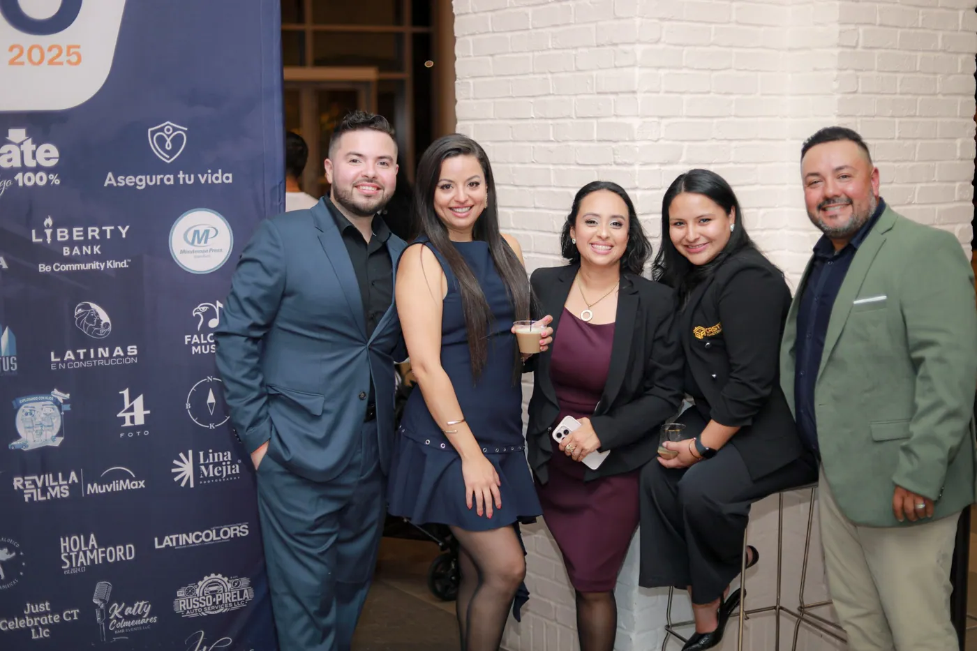 Attendees posing in front of the Expo Comercio Latino backdrop